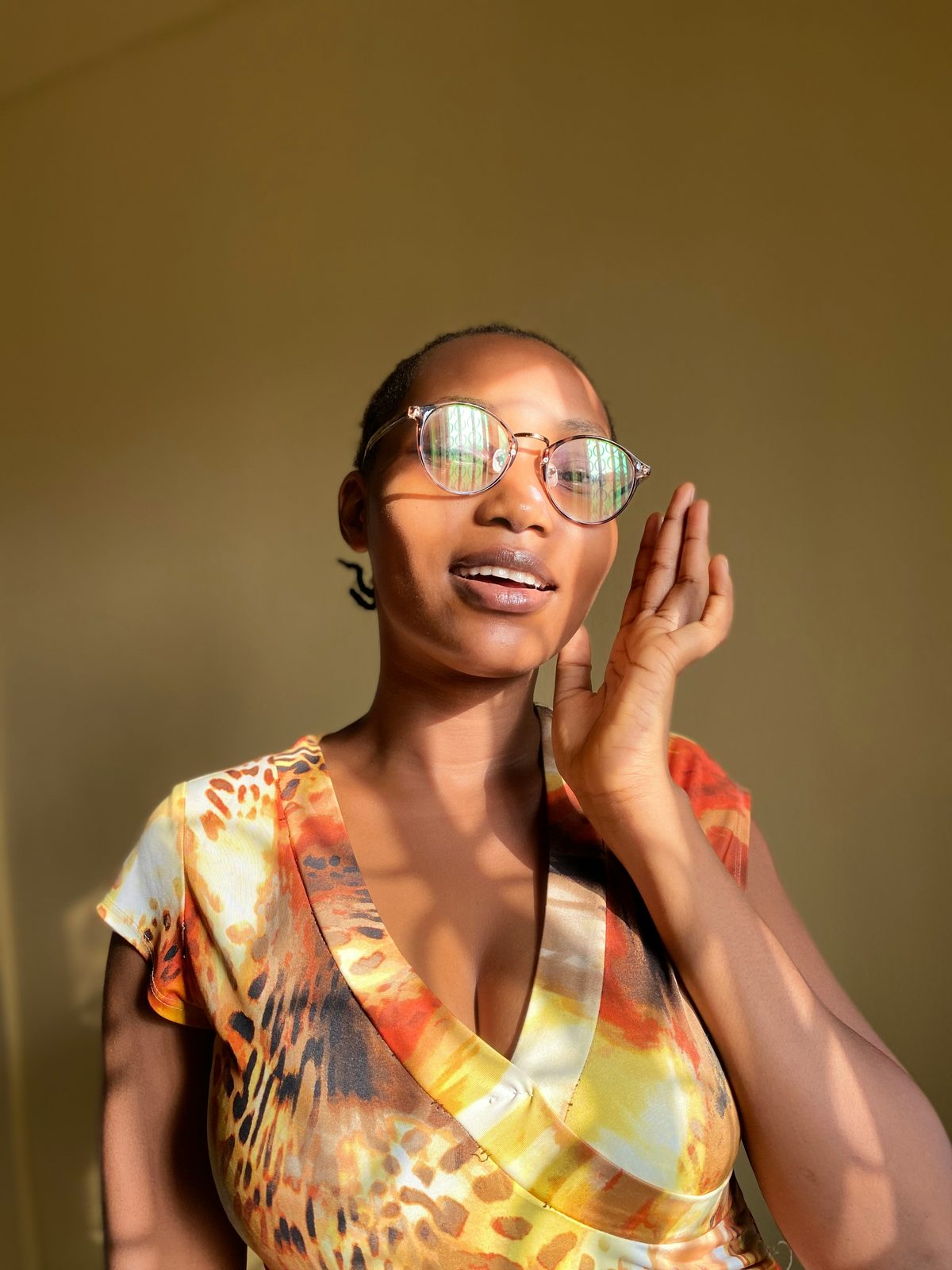 A smiling woman wearing gold-rimmed eyeglasses.