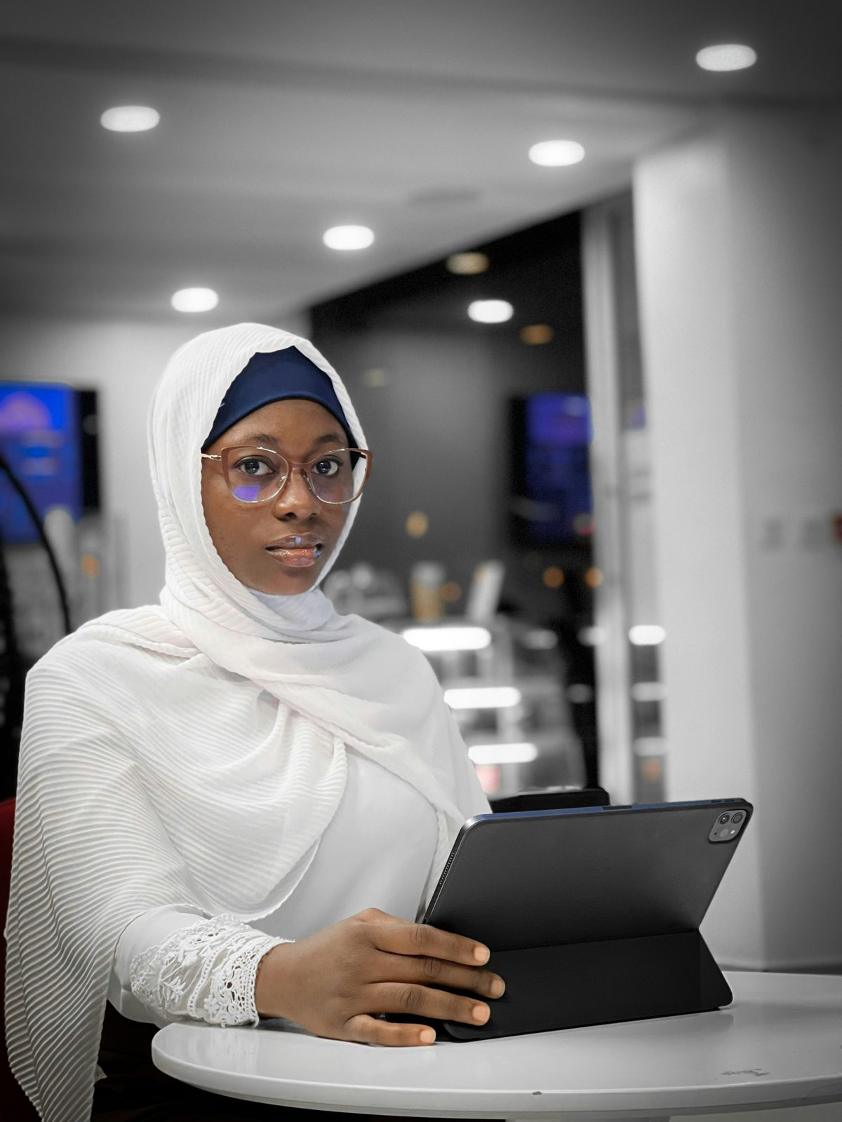 A woman in glasses working at a tablet.