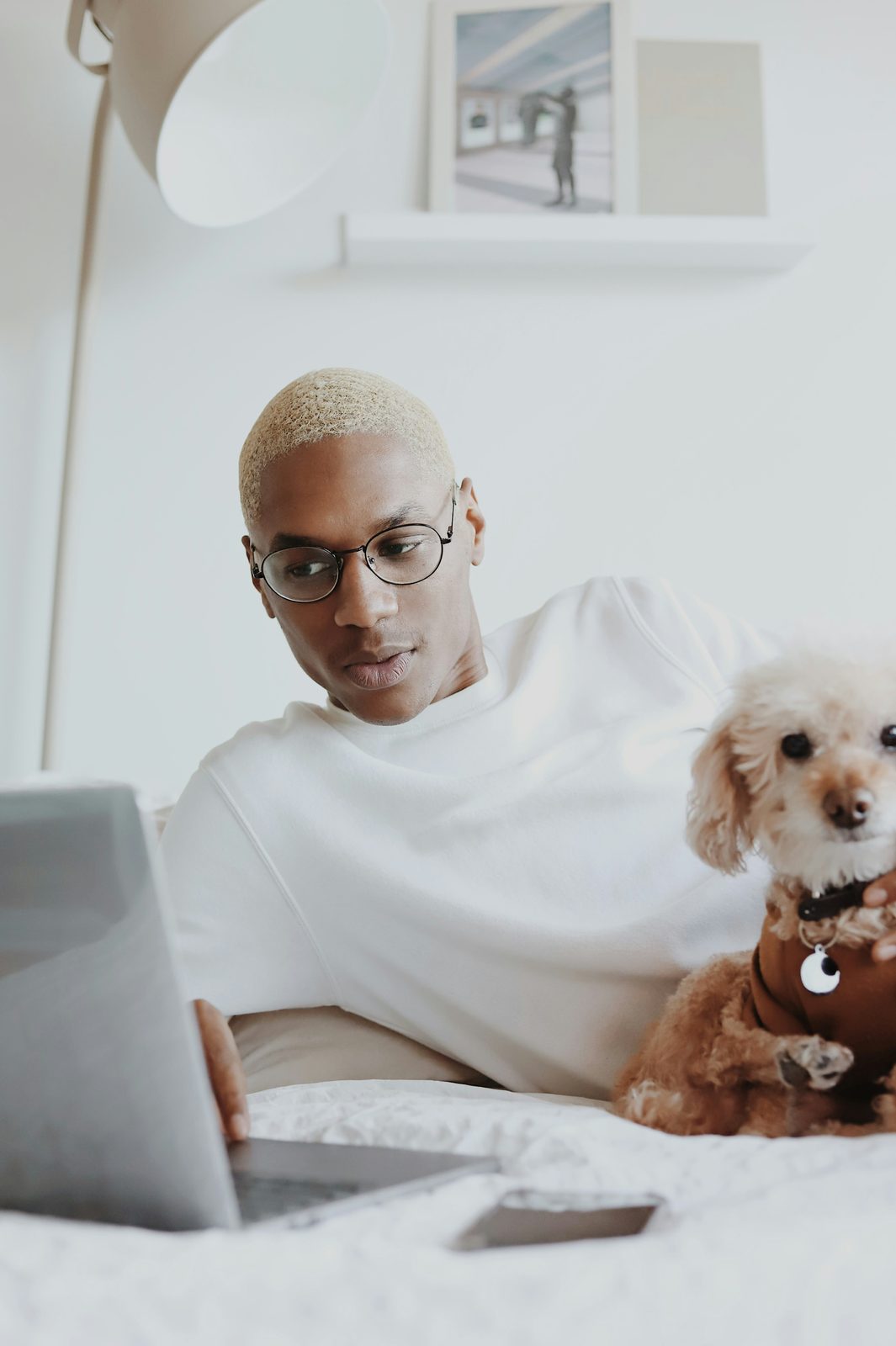 A man in glasses reading at a laptop.